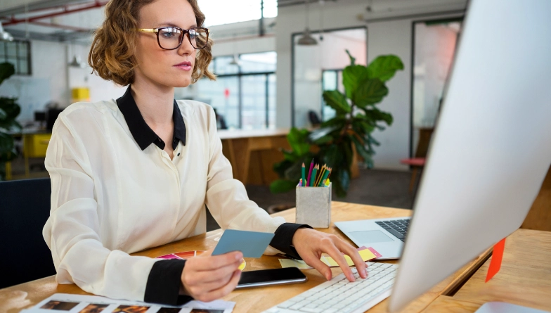 Woman at desk reviewing print documents